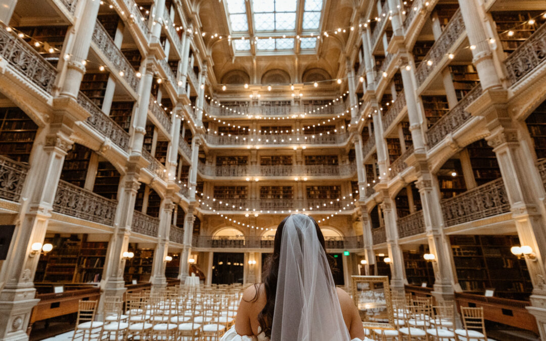 Bride in a large library with 4 stories of books.